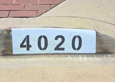 Freshly painted black curb address number on a white background in Los Angeles