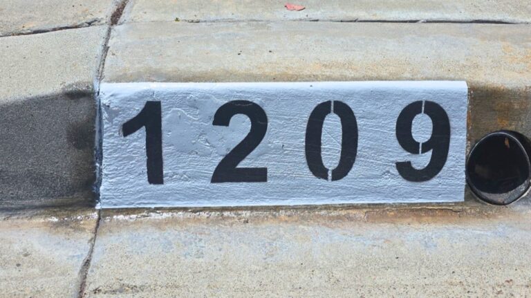 Painted curb address number 1209 in black on a white background, Los Angeles Painted curb address number 1209 in black on a white background, Los Angeles
