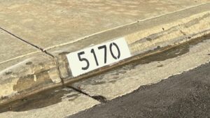 Painted curb address number 5170 in black on a white background, Los Angeles