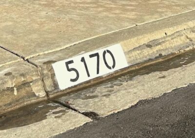 Freshly painted black curb address number on a white background in Los Angeles