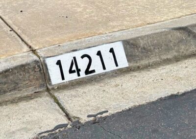 Freshly painted black curb address number on a white background in Los Angeles