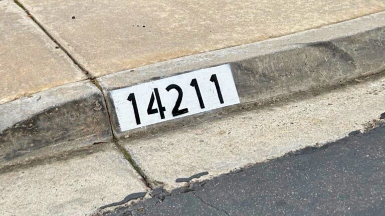 Painted curb address number 14211 in black on a white background, Los Angeles