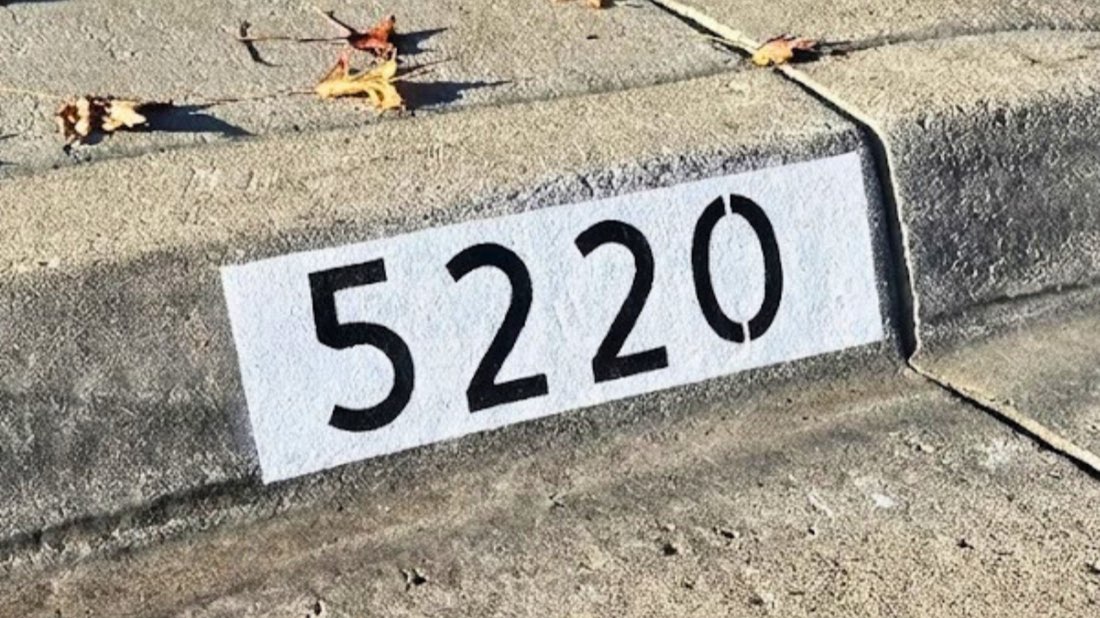 Los Angeles curb painting expert painting a black address number on a curb
