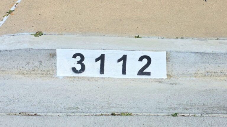 Painted curb address number 3112 in black on a white background, Los Angeles